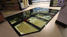 insolito: en medio de un supermercado se exhibe un suelo de cristal con restos arqueologicos
